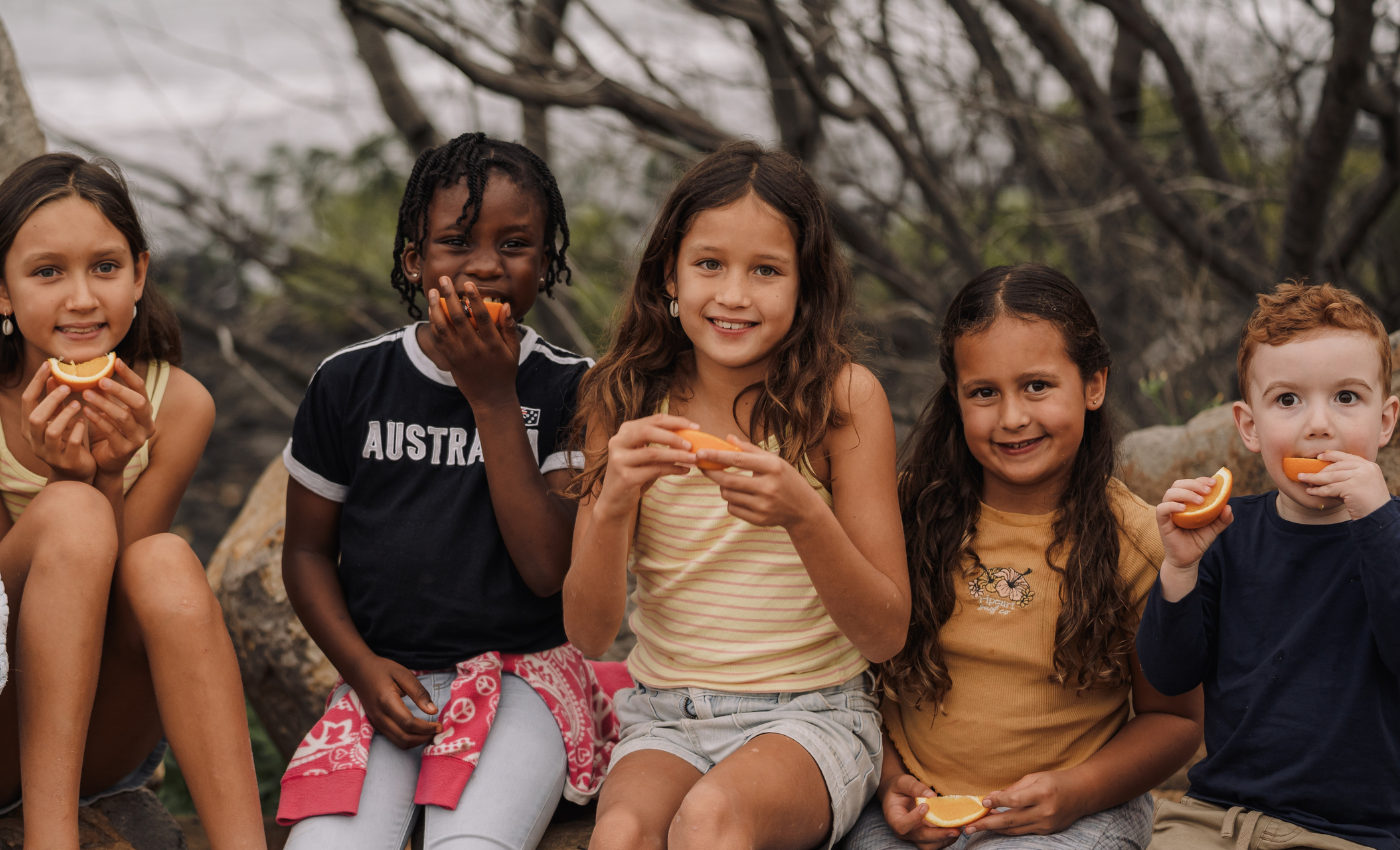 group of children eating oranges