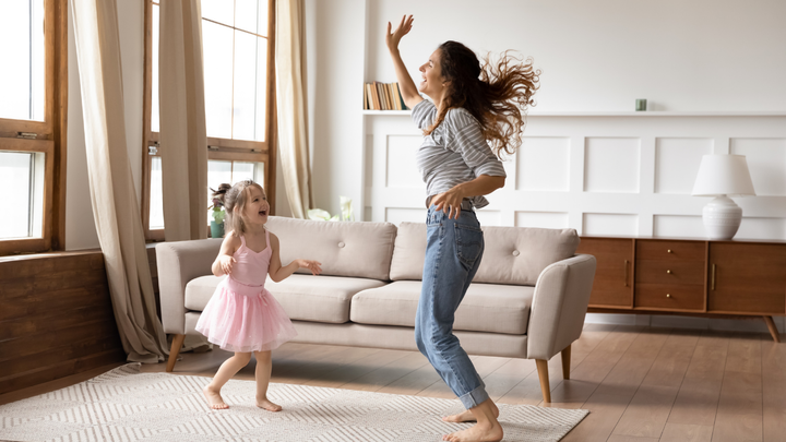 Mother and daughter dance in loungeroom