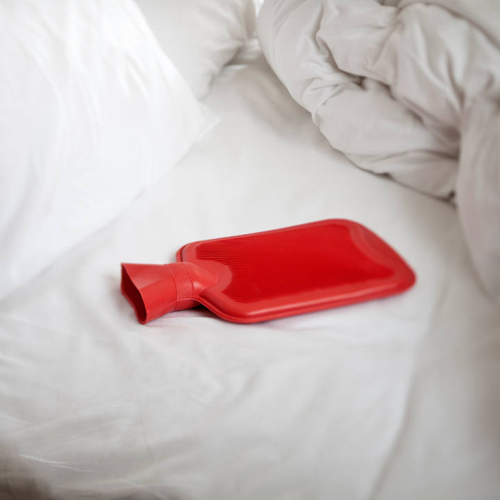 hot water bottle in unmade bed